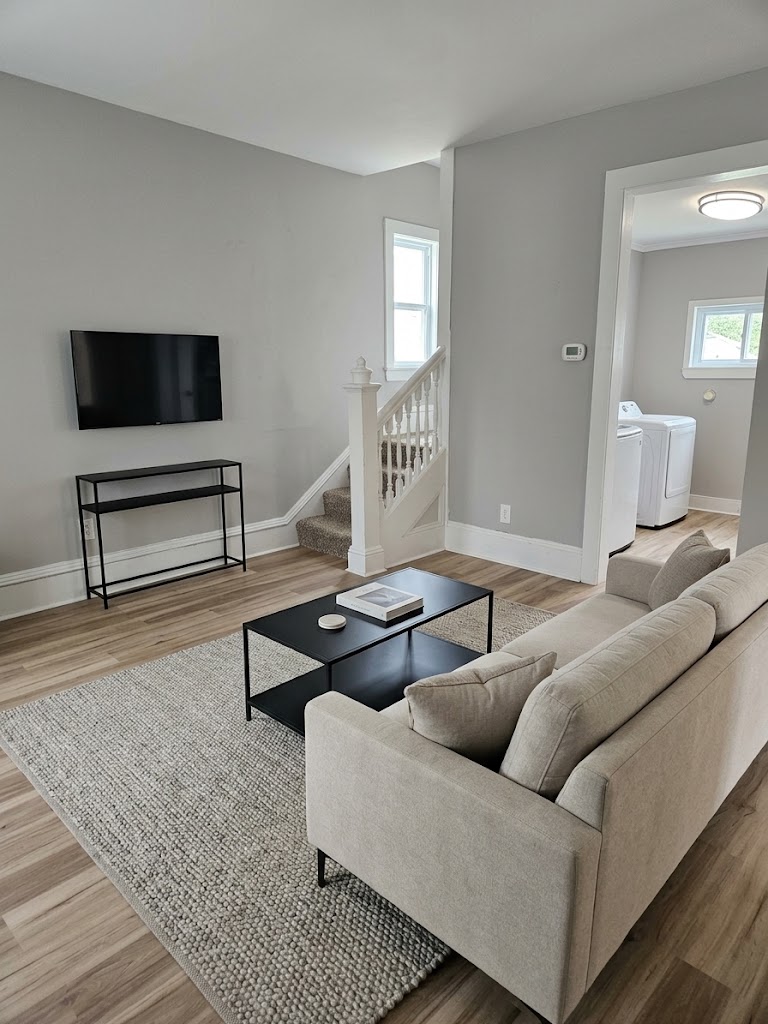 Furnished living room with sofa, TV, and laundry room
